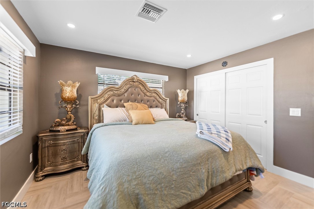 1200 Patterson Road Cape Coral, FL 33909 - Photo 14 of 42 a bedroom with a bed and wooden floor