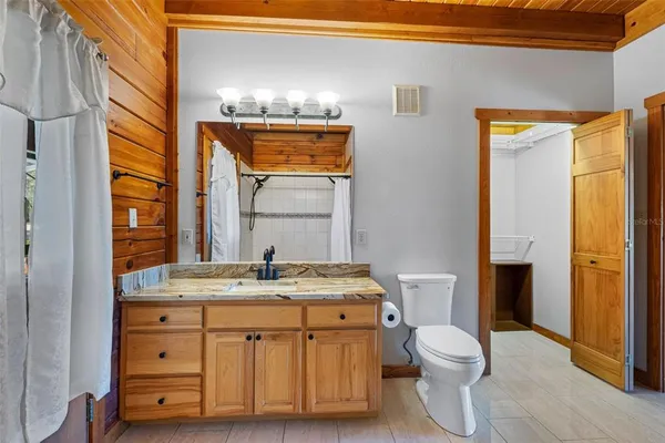 a bathroom with a granite countertop sink mirror vanity and toilet