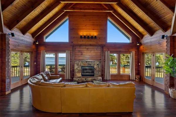 a living room with fireplace furniture and a large window