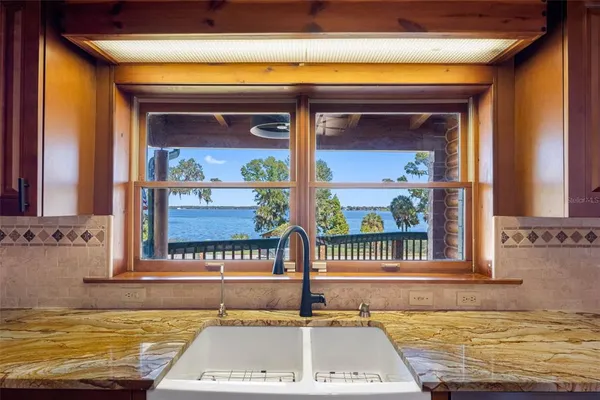 a view of living room kitchen with stainless steel appliances wooden floor and living room view
