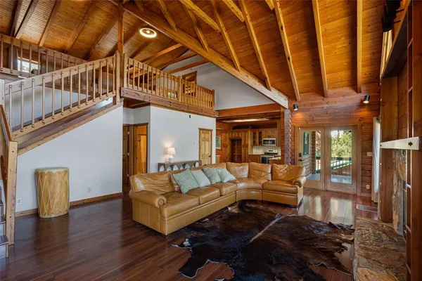 a view of living room kitchen with stainless steel appliances wooden floor and living room view