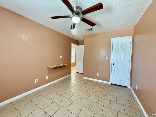 a view of a room with a ceiling fan and a window