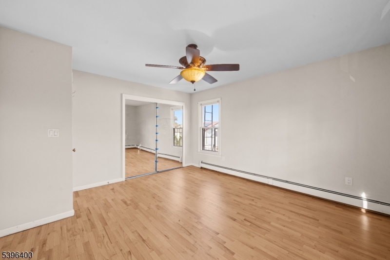 136 Clifton Boulevard Clifton, NJ 07011 - Photo 11 of 16 a view of an empty room with window and wooden floor