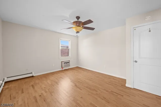 a view of a room with wooden floor and a ceiling fan