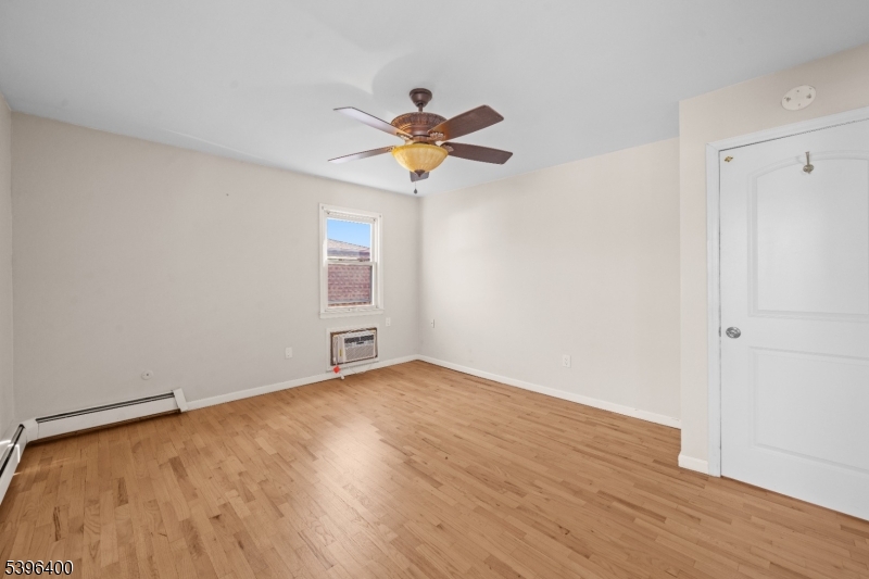 136 Clifton Boulevard Clifton, NJ 07011 - Photo 12 of 16 a view of a room with wooden floor and a ceiling fan