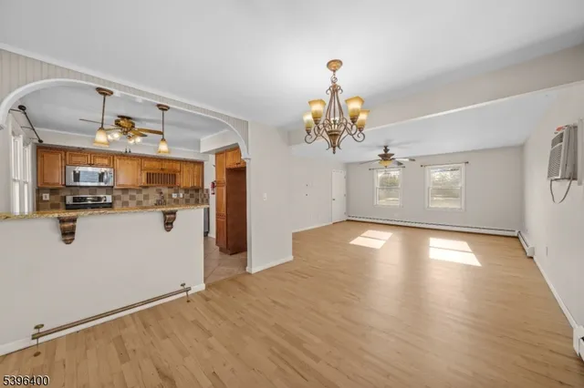 a view of a room with wooden floor and chandelier