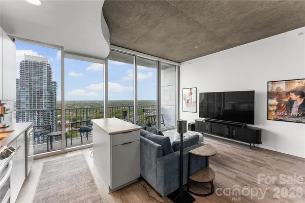 a living room with furniture tv and large windows
