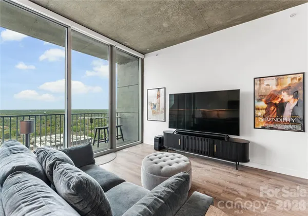 a living room with furniture tv and a floor to ceiling window