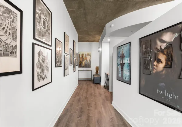a view of a hallway with wooden floor and furniture