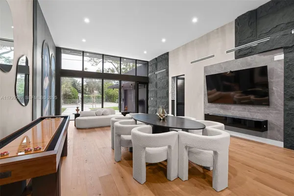 a living room with furniture a flat screen tv and a large window