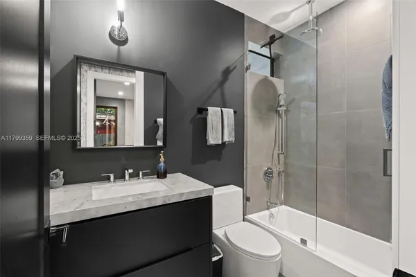 a bathroom with a sink vanity mirror and toilet