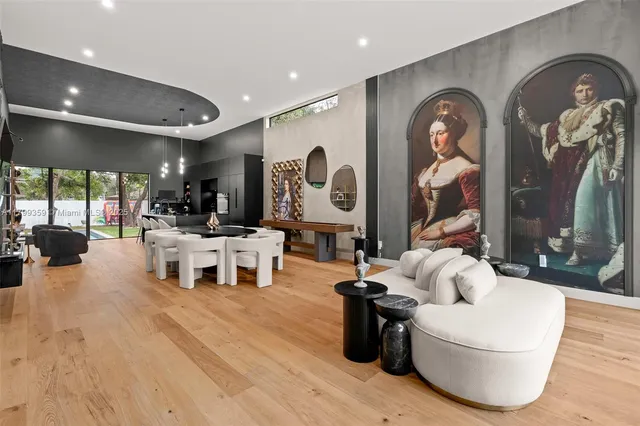 a living room with couches and kitchen view with wooden floor