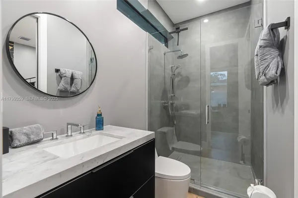 a bathroom with a sink a toilet and a mirror