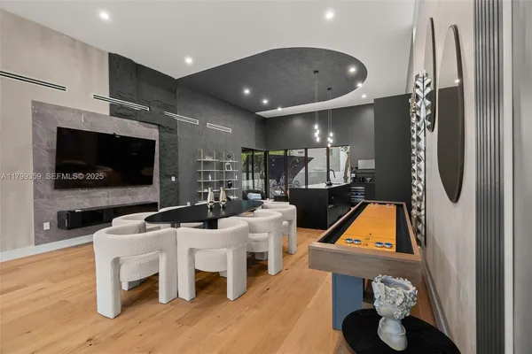 a living room with furniture a flat screen tv and kitchen view