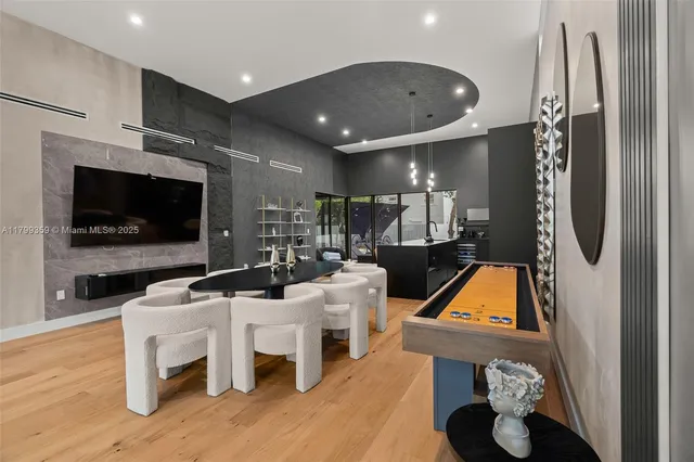 a living room with furniture a flat screen tv and kitchen view