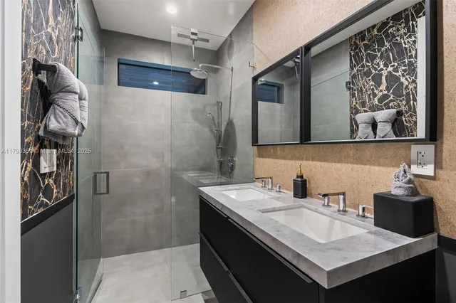 a bathroom with a sink shower and a mirror