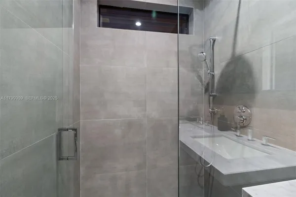 a bathroom with a sink shower and a mirror