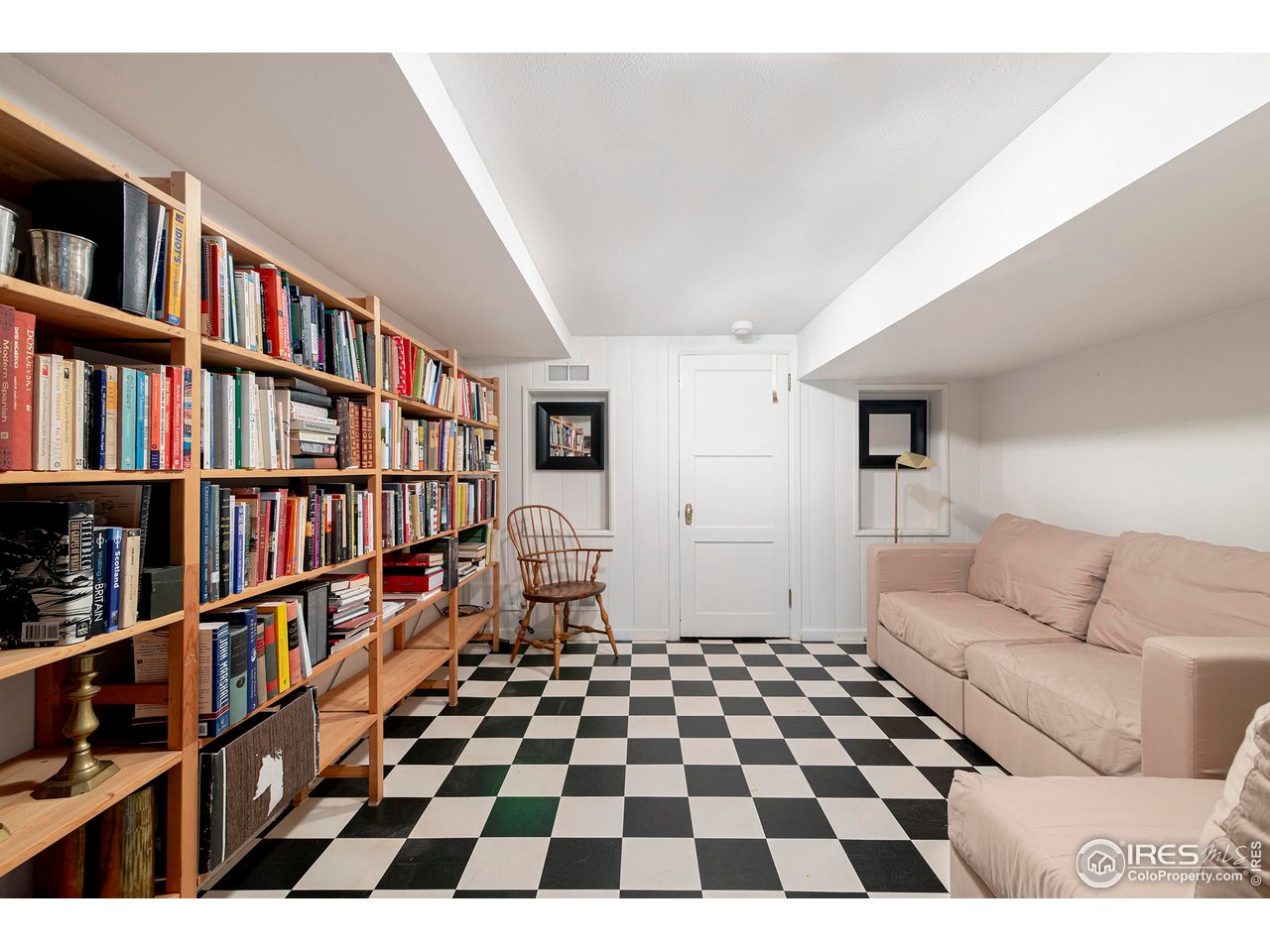 764 14th Street Boulder, CO 80302 - Photo 36 of 40 a living room with a black white checkered floor and a book shelf