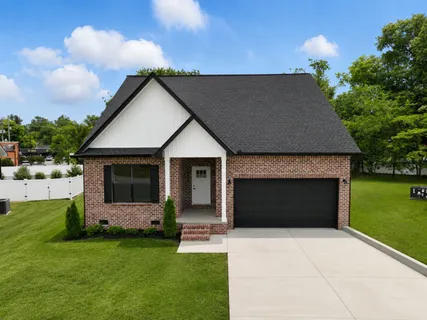 a front view of a house with a garden and yard