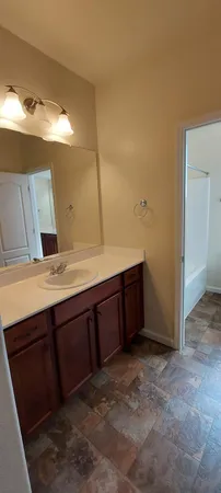 a bathroom with a double vanity sink toilet mirror and bathtub