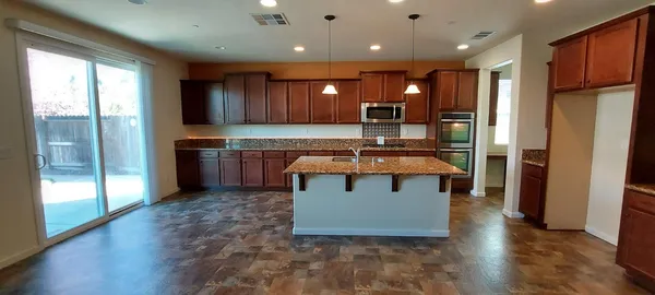 a kitchen with stainless steel appliances granite countertop a refrigerator a oven and a sink