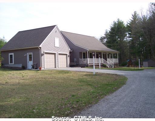 a front view of a house with a garden and trees