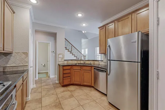 a kitchen with stainless steel appliances granite countertop a refrigerator and a stove