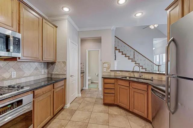 a kitchen with stainless steel appliances granite countertop a sink and cabinets