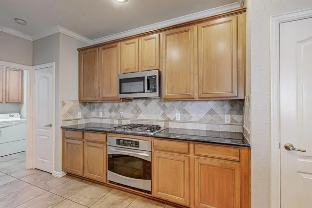 a kitchen with granite countertop white cabinets stainless steel appliances and a sink