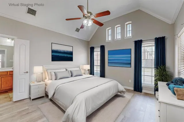 a bedroom with a large bed a chandelier and windows