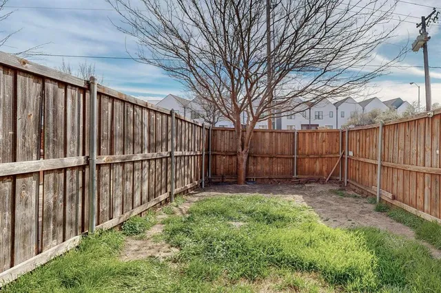 a view of a backyard with wooden fence