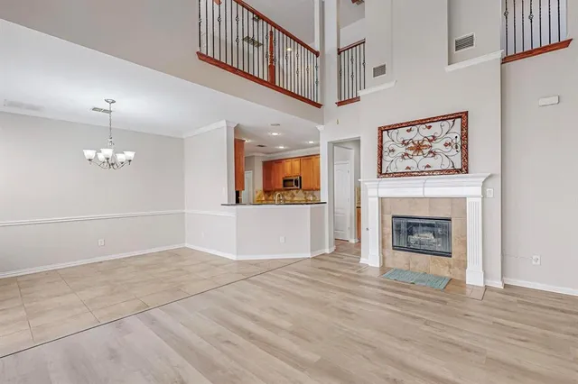 an empty room with windows fireplace and a chandelier
