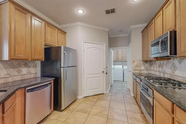 a kitchen with stainless steel appliances granite countertop a refrigerator stove and sink