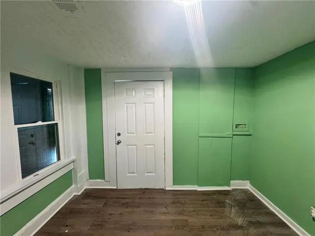a view of a room with wooden floor