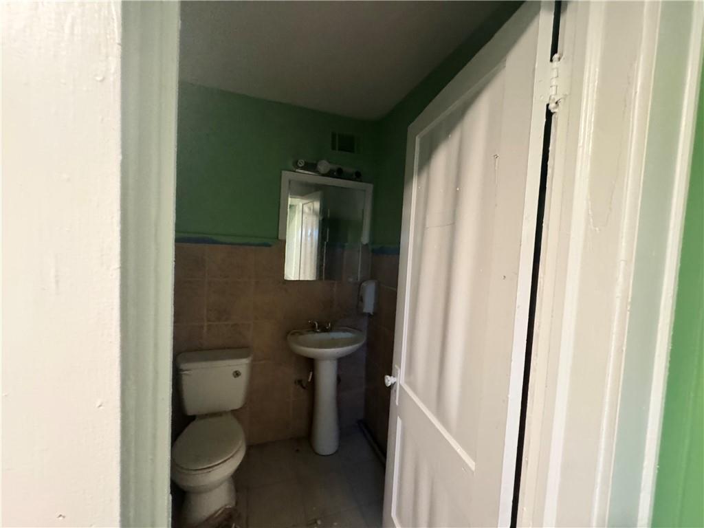 1292 Ralph David Abernathy Boulevard Atlanta, GA 30310 - Photo 3 of 16 a bathroom with a toilet sink and mirror