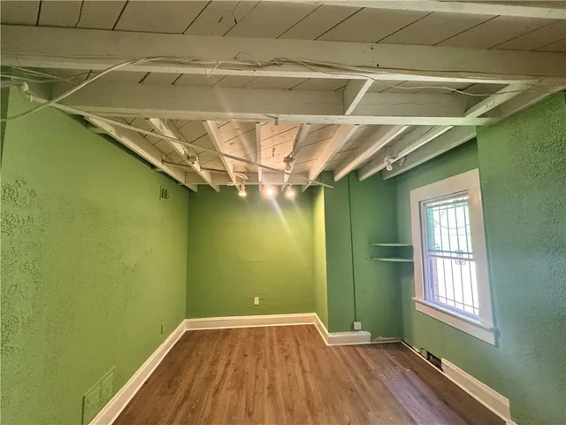 a view of a room with wooden floor and a window