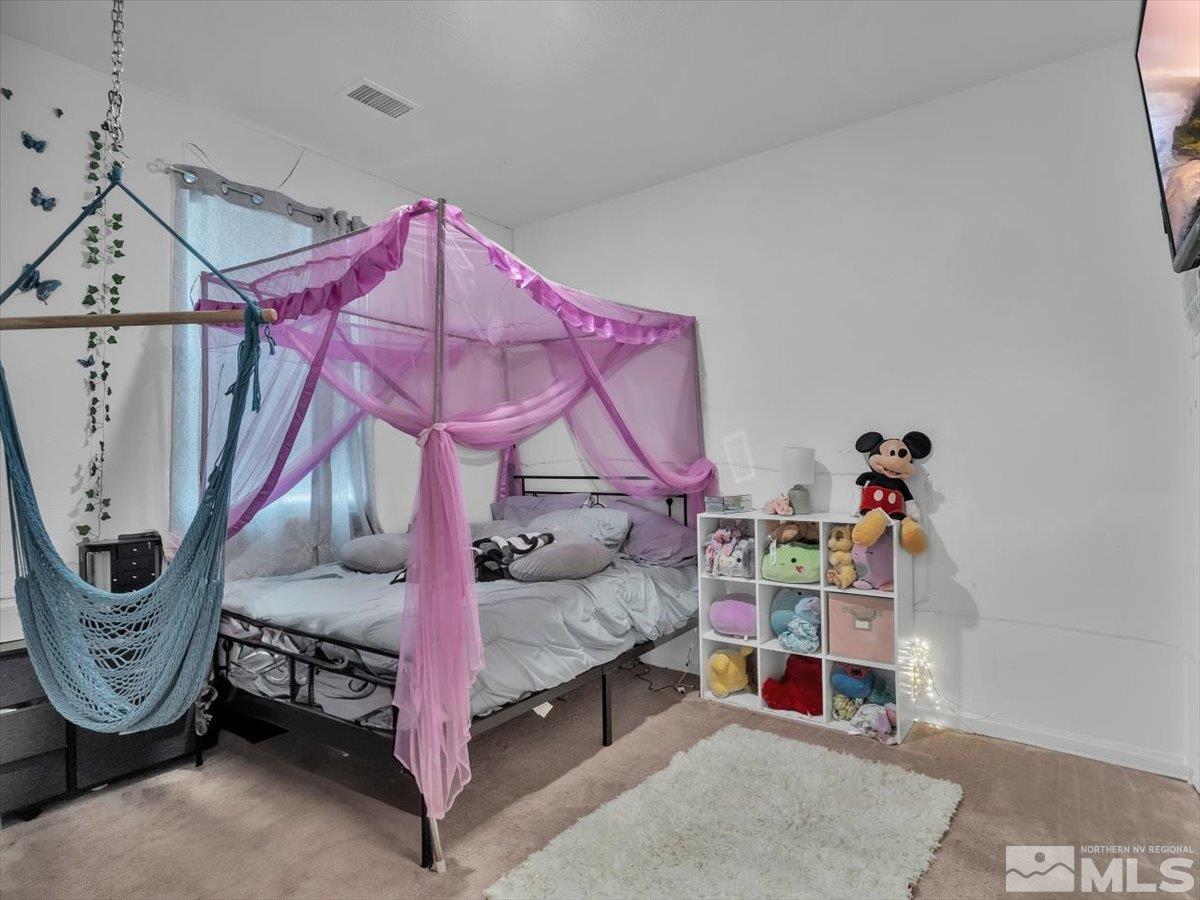 119 Oakmont Drive Dayton, NV 89403 - Photo 11 of 19 a bedroom with furniture and a chandelier