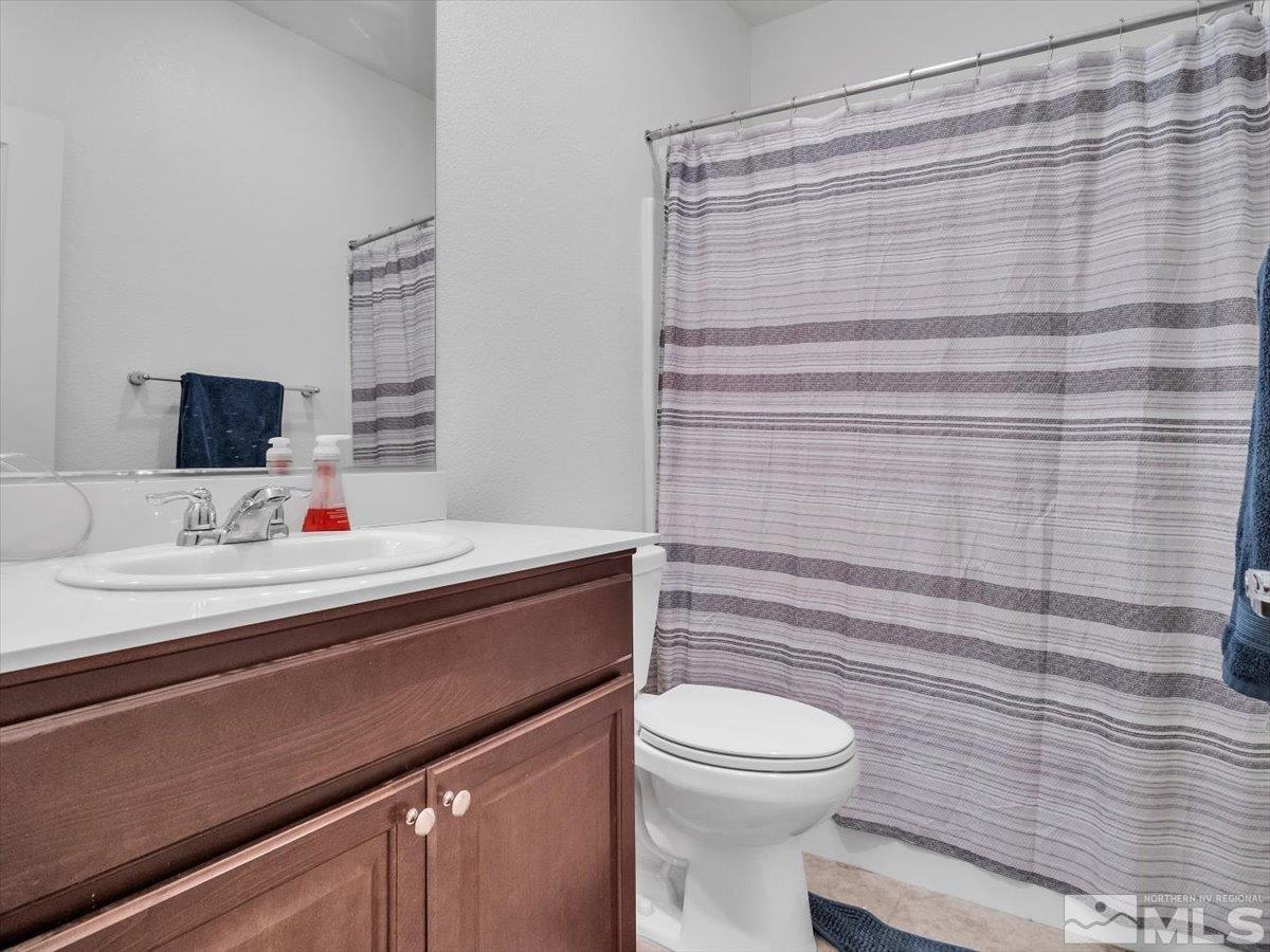 119 Oakmont Drive Dayton, NV 89403 - Photo 14 of 19 a bathroom with a sink a toilet and shower curtain