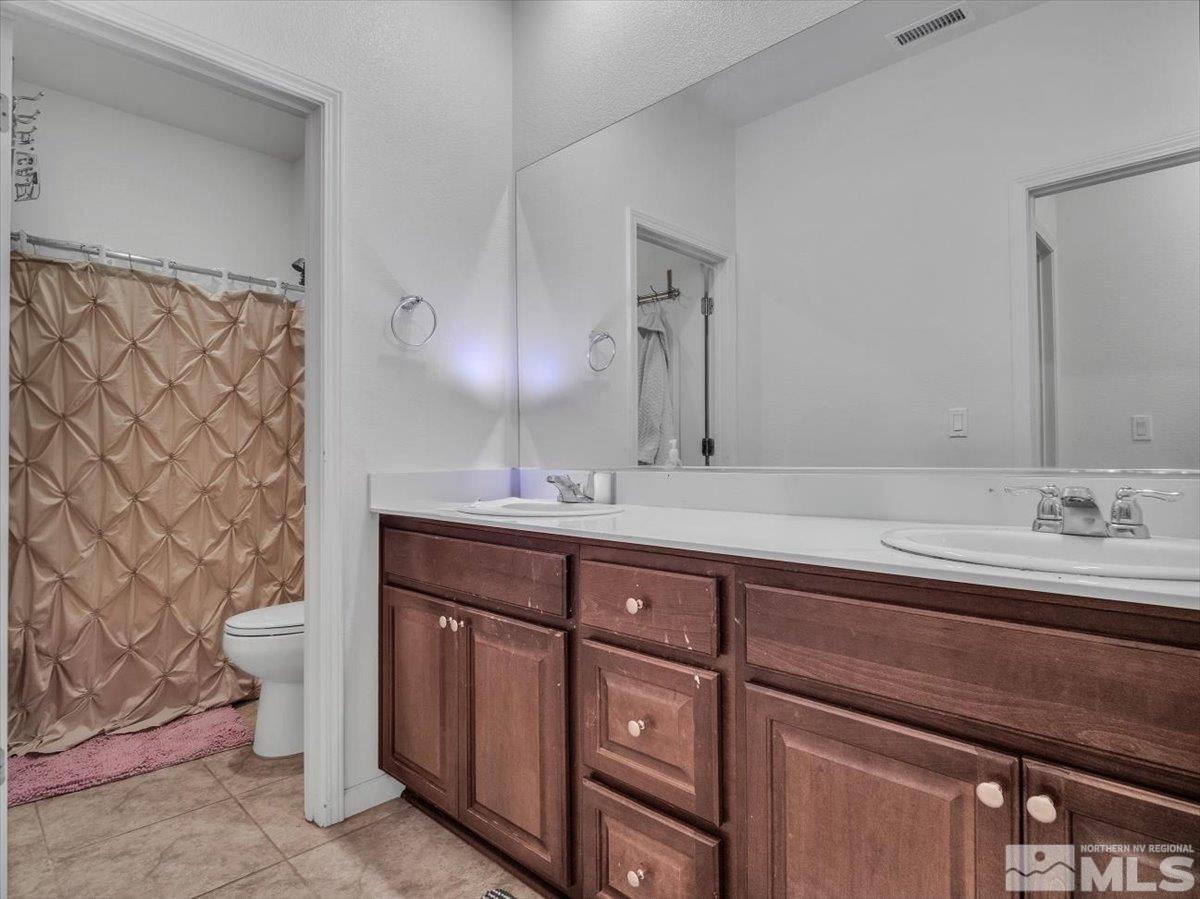 119 Oakmont Drive Dayton, NV 89403 - Photo 16 of 19 a bathroom with a double vanity sink and a mirror