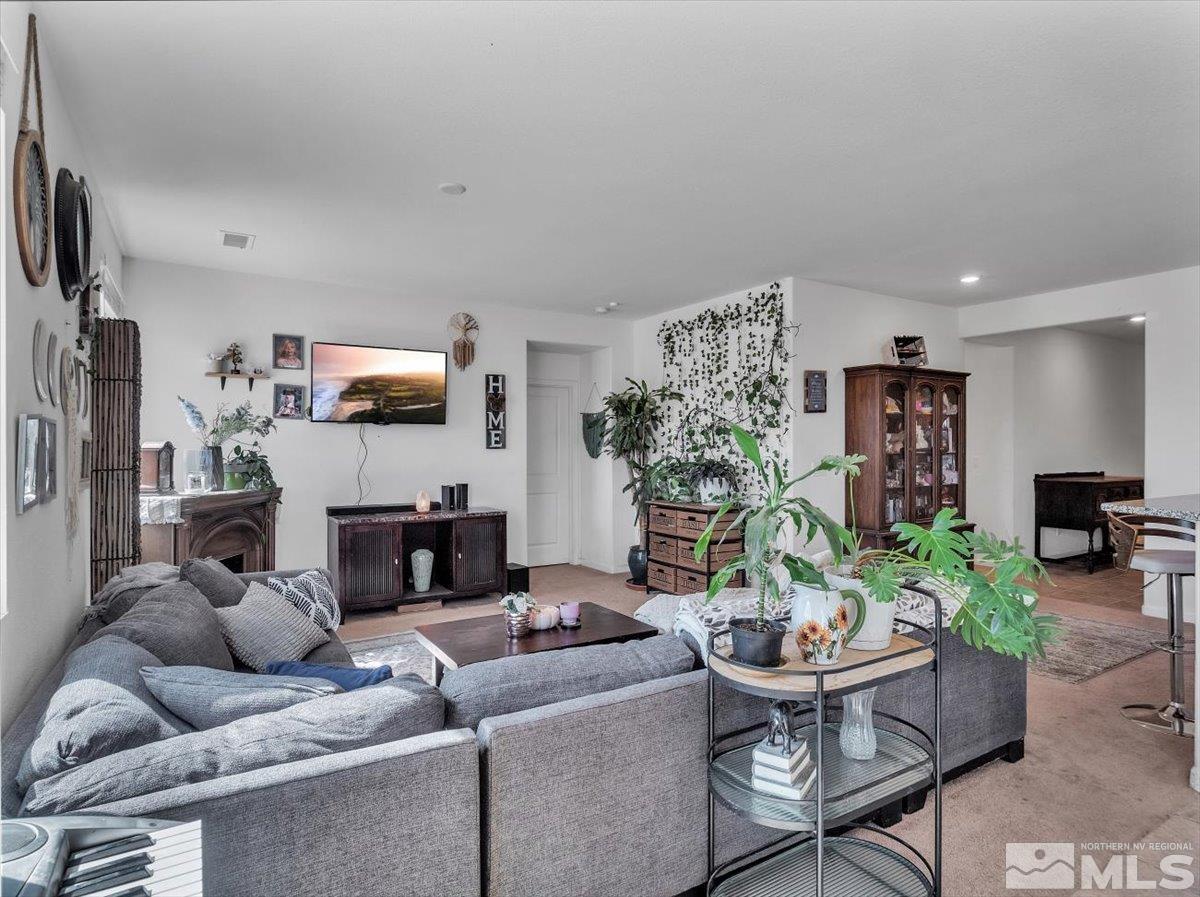 119 Oakmont Drive Dayton, NV 89403 - Photo 4 of 19 a living room with furniture a fireplace and a flat screen tv