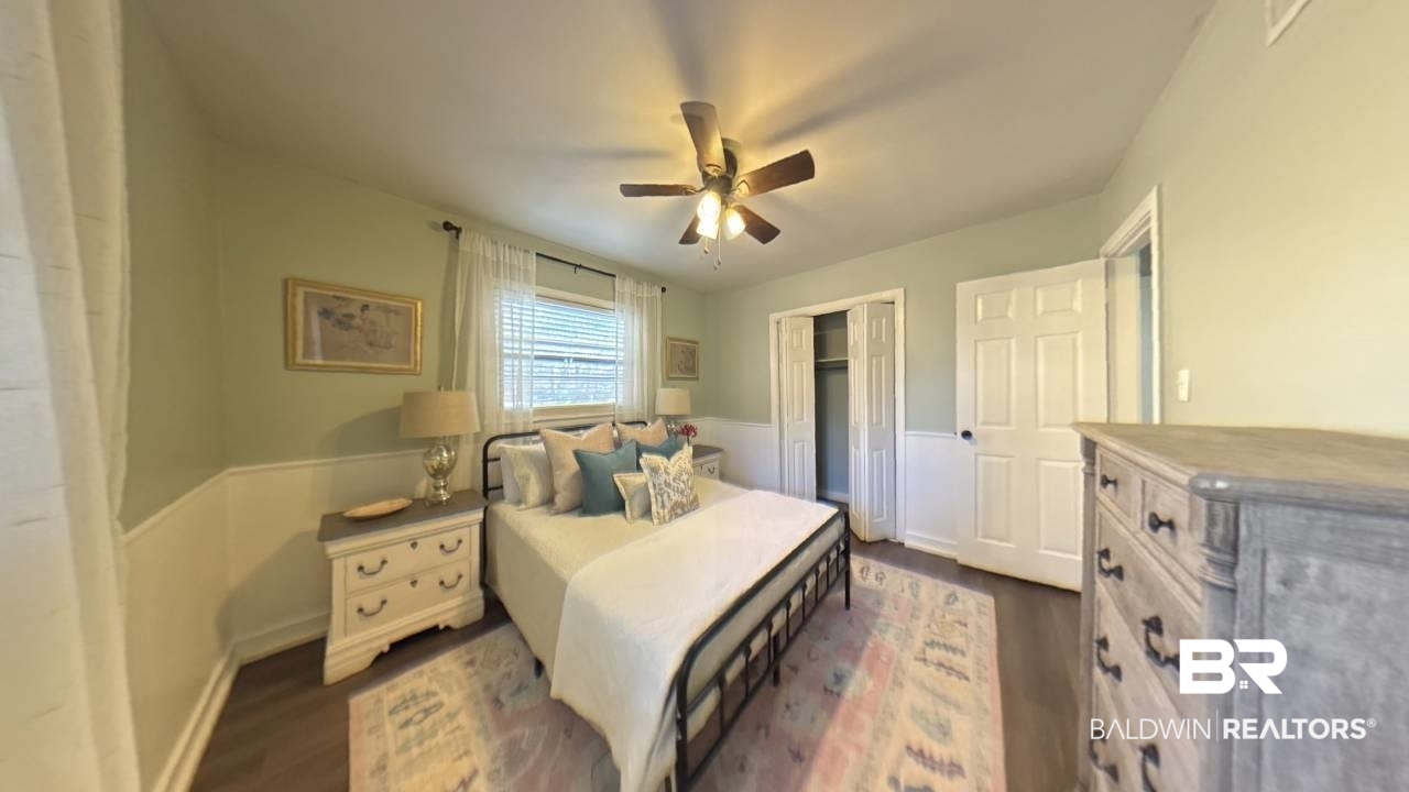 1703 Clark Avenue Bay Minette, AL 36507 - Photo 7 of 27 Bedroom featuring a wainscoted wall, ceiling fan, a closet, and dark wood finished floors