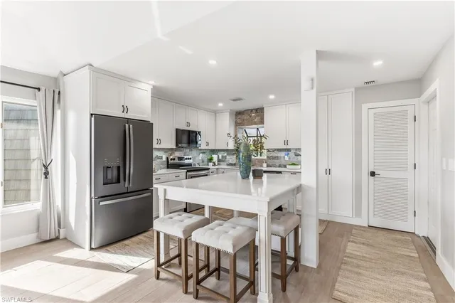 a kitchen with stainless steel appliances a refrigerator a stove a sink and a oven