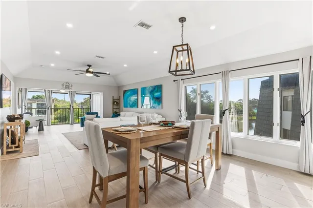 a view of a dining room and livingroom with furniture wooden floor a chandelier