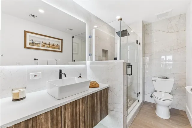 a bathroom with a sink a toilet and a large mirror