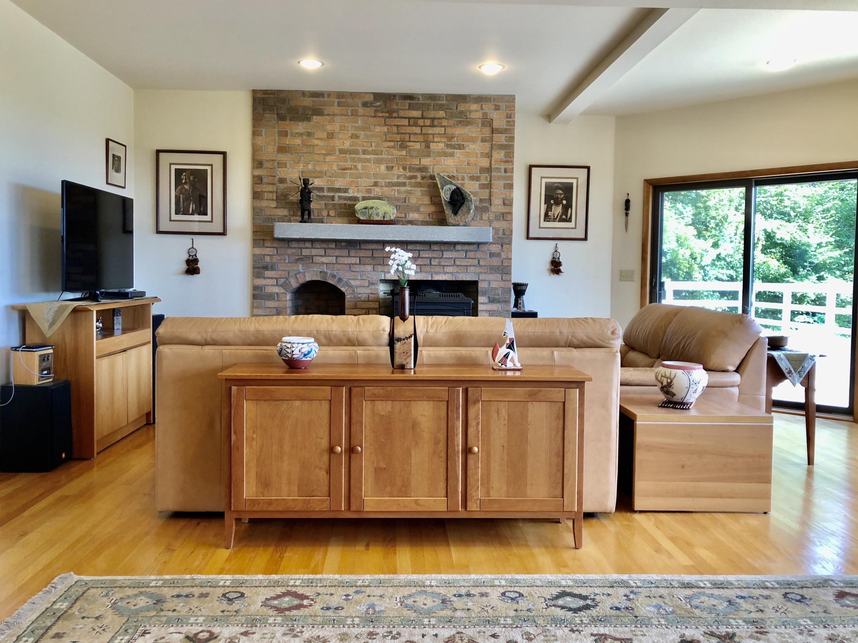 359 Harrington Road Otis, MA 01253 - Photo 16 of 60 a living room with furniture a flat screen tv and a fireplace