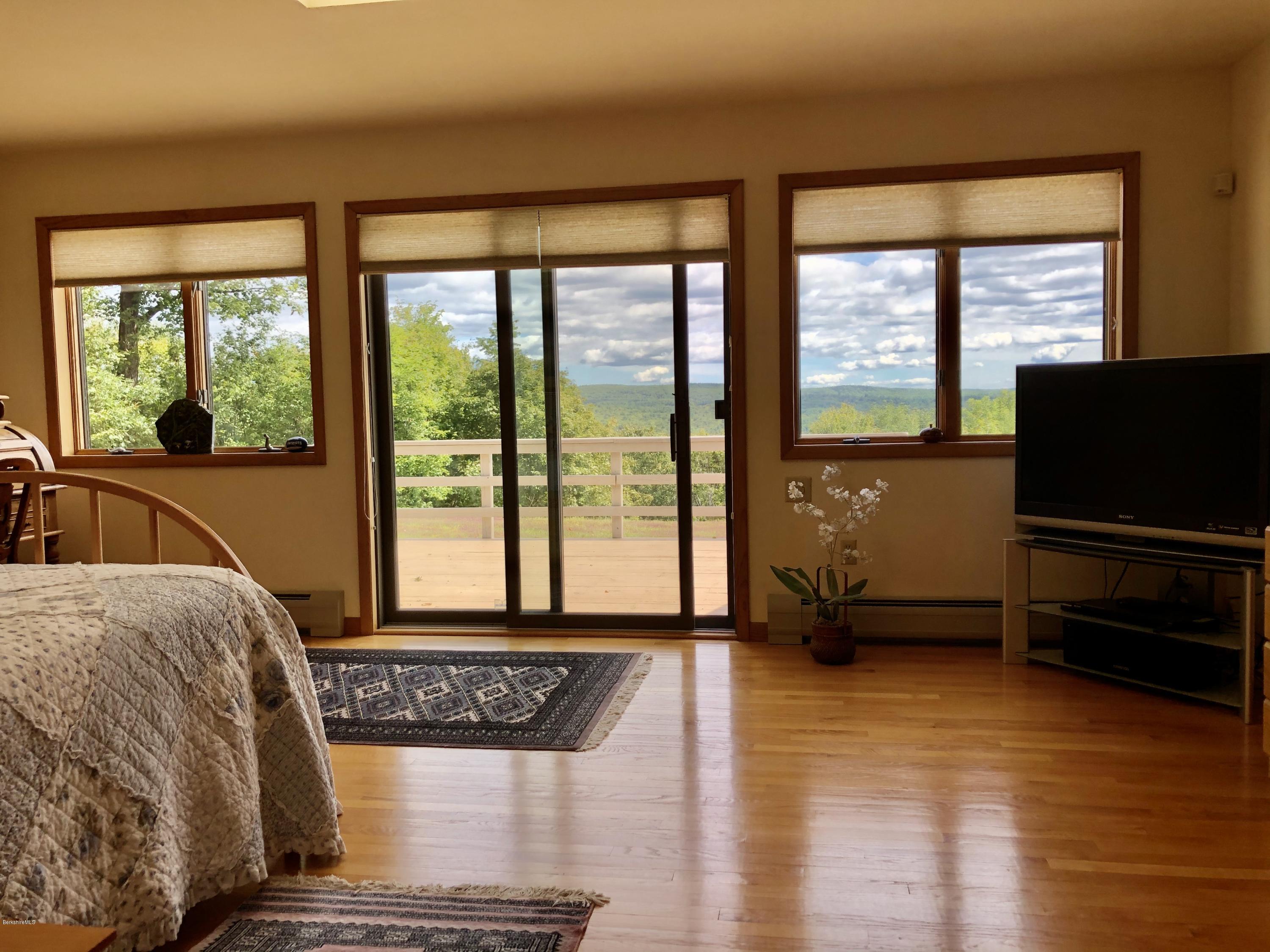 359 Harrington Road Otis, MA 01253 - Photo 25 of 60 a living room with a large window and a flat screen tv