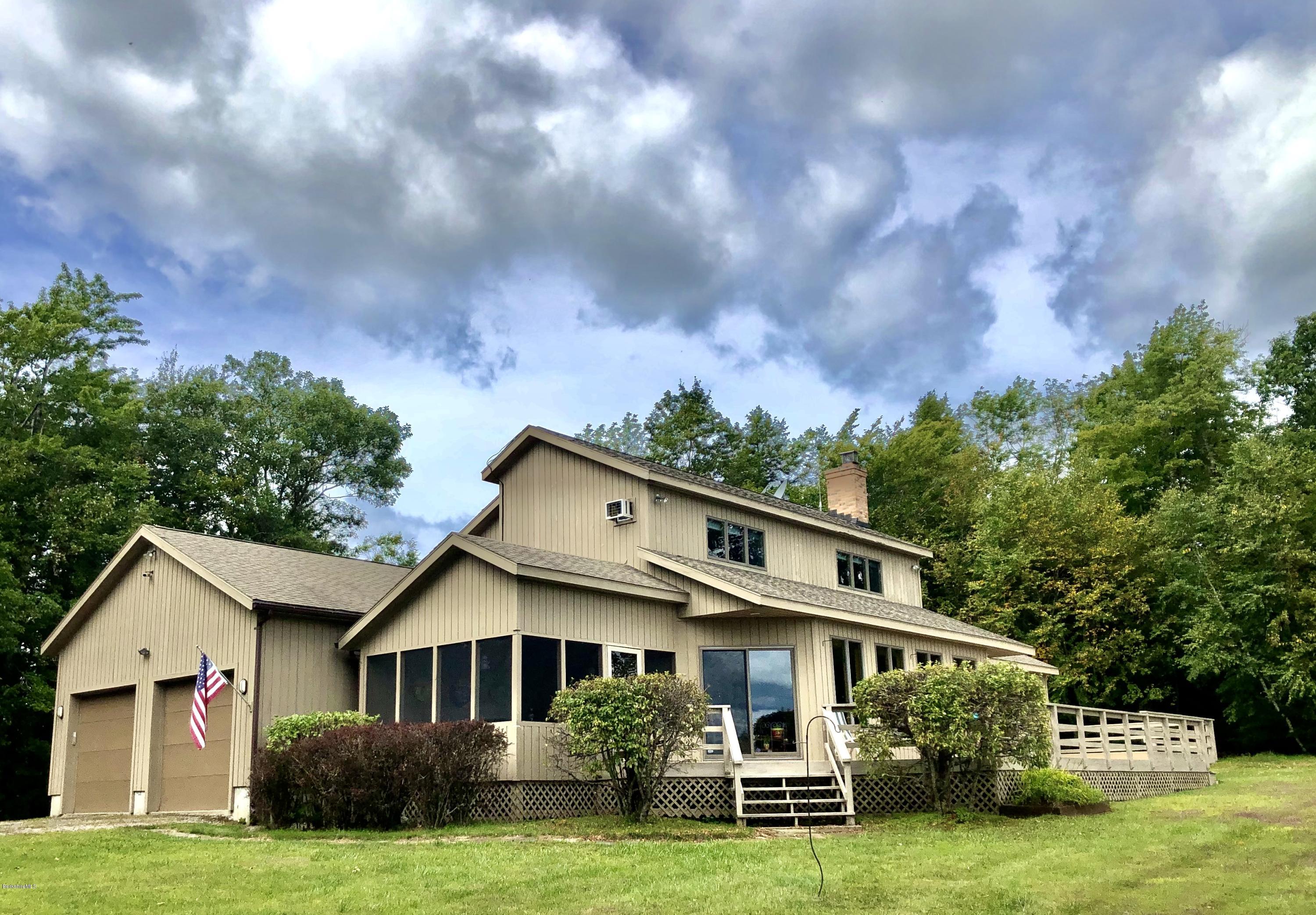 359 Harrington Road Otis, MA 01253 - Photo 5 of 60 a view of a white house next to a yard with big trees