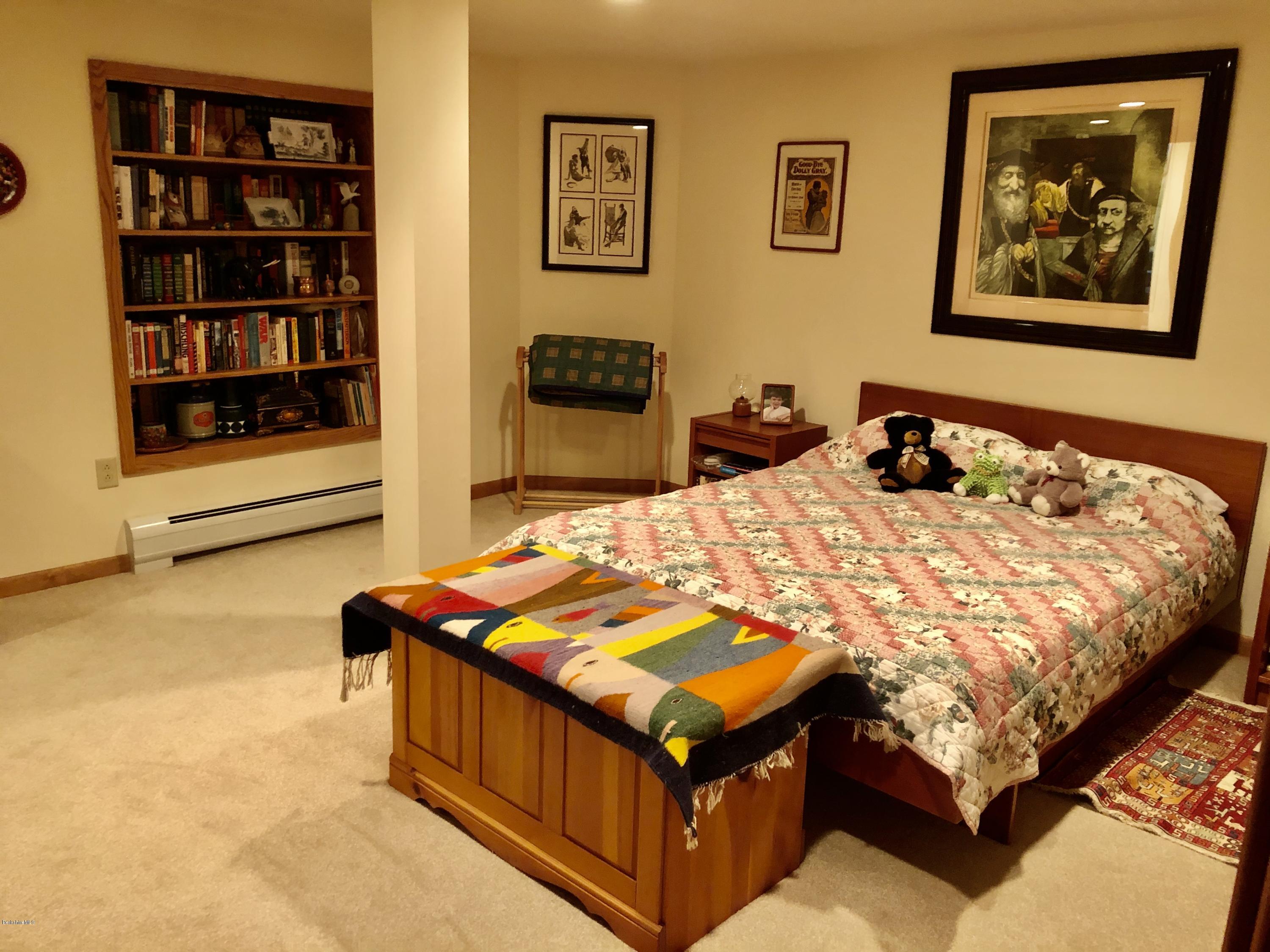 359 Harrington Road Otis, MA 01253 - Photo 42 of 60 a bed sitting in a bedroom next to a book shelf