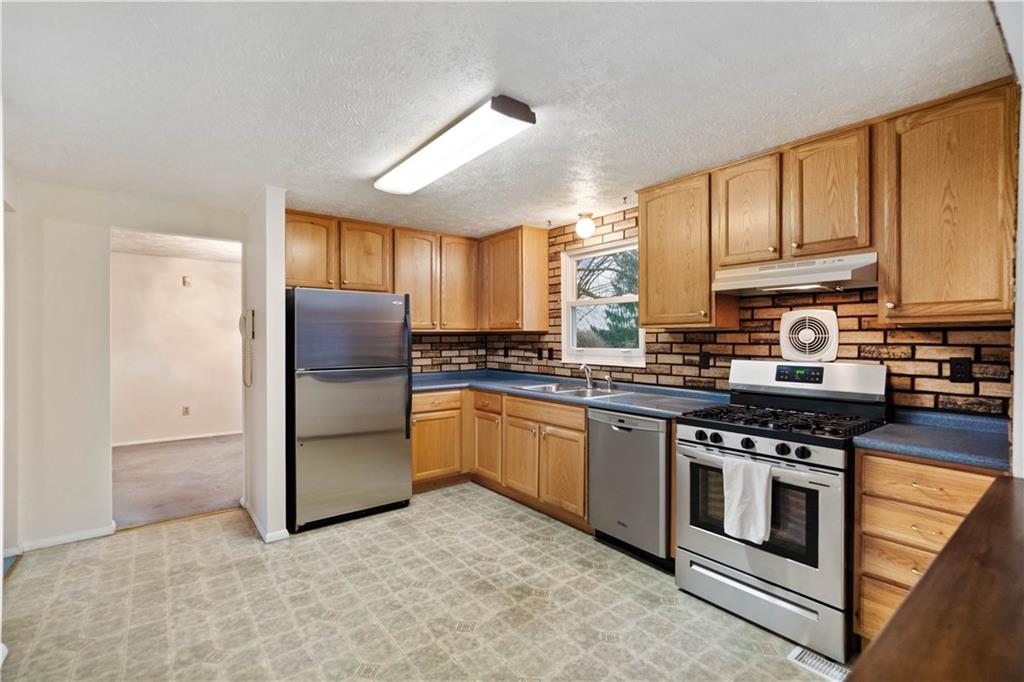 106 Pheasant Run Drive Export, PA 15632 - Photo 7 of 25 a kitchen with stainless steel appliances granite countertop a stove a refrigerator and a sink