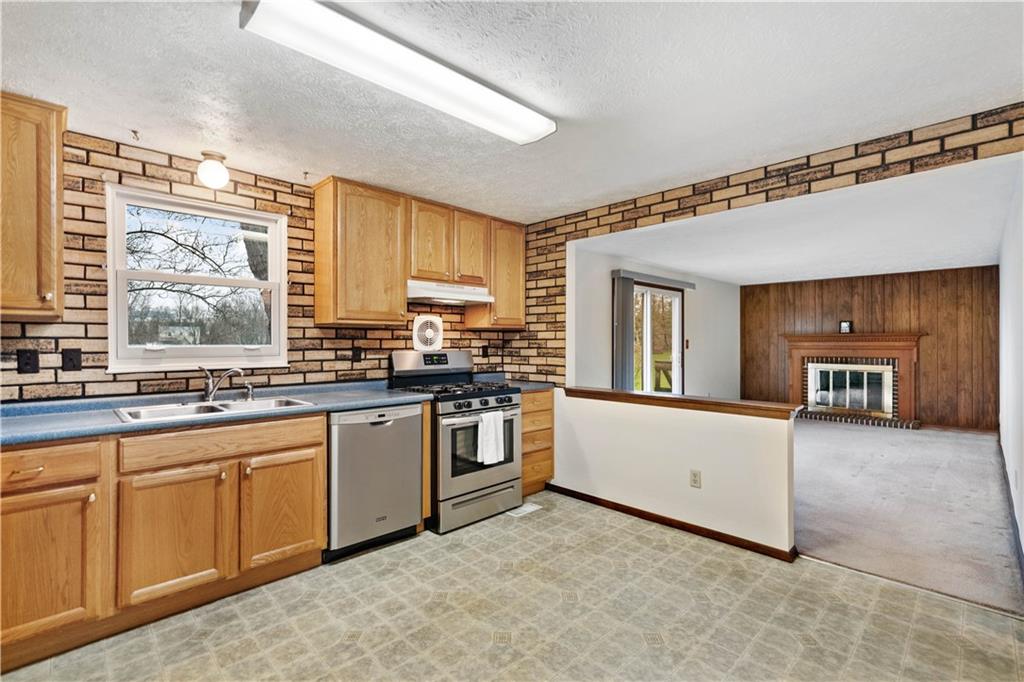 106 Pheasant Run Drive Export, PA 15632 - Photo 9 of 25 a kitchen with stainless steel appliances granite countertop a stove a sink and a refrigerator